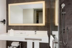 a bathroom with a white sink and a shower at AC Hotel San Jose Airport Belen in San José