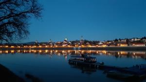 un bateau sur un lac avec une ville la nuit dans l'établissement Réved(ez), à Szigetmonostor
