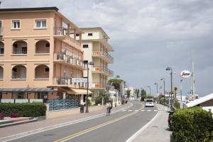 una persona que va en bicicleta por una calle junto a un edificio en Hotel Euro, en Bellaria-Igea Marina