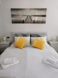 un grande letto con due cuscini gialli sopra di Apartment Maslina a Vrboska (Verbosca)