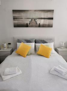 a large bed with two yellow pillows on it at Apartment Maslina in Vrboska +17 photos