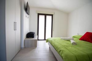 a bedroom with a green bed and a television at La Finestra Sul Mare in Lanusei