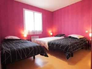 2 camas en una habitación con paredes rojas en Le saoutot, en Saint-Jean-de-Marsacq