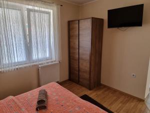a bedroom with a bed and a dresser with a television at Apartments Lean in Poreč