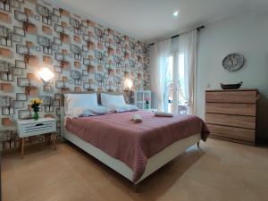 a bedroom with a bed and a wall with pictures at Psatha by CorfuEscapes in Kynopiástai