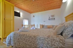 a bedroom with a large bed and a yellow door at To Patriko Mas Guesthouse-1 in Palaios Panteleimonas