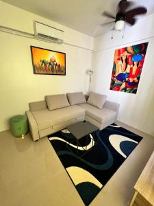 sala de estar con sofá y mesa en Cozy almond drive condo in cebu en Talisay