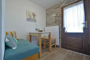 Habitación con mesa, mesa y puerta en To Patriko Mas Guesthouse-1, en Palaios Panteleimon