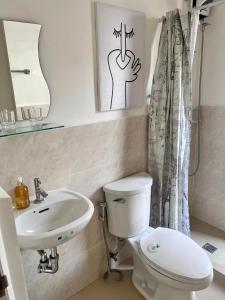 a bathroom with a white toilet and a sink at Cozy almond drive condo in cebu in Talisay
