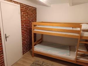 Cette chambre dispose de lits superposés et d'un mur en briques. dans l'établissement Cottage Auto Camp Vinac, à Jajce