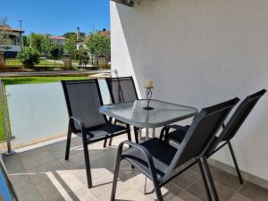 a table and chairs on a patio with a view of a pool at Apartments Lean in Poreč