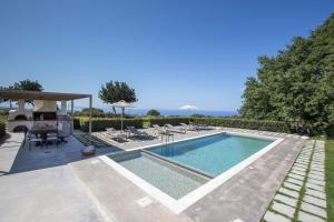 a swimming pool in a villa with a table and chairs at Lux Villa Mia with Heated Pool, 2km to Beach & Childrens Area! in Mikro Metochi