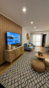 uma sala de estar com uma grande televisão de ecrã plano em Pérola dos Salgados na Guia