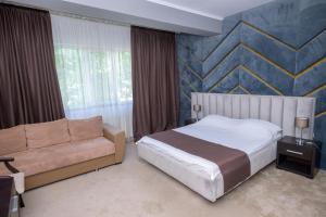 a bedroom with a bed and a couch at Hotel Maryiotis in Constanţa