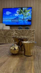 uma mesa com um vaso e uma televisão num quarto em Pérola dos Salgados em Guia