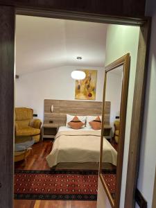 a bedroom with a large bed and a mirror at Apartments Prizreni in Prizren