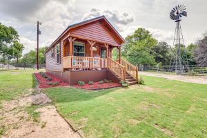 een houten hut met een terras en een windmolen bij Rustic Texas Getaway with Grill on 30 Acres in Weatherford