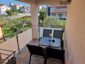 a patio with a table and chairs on a balcony at Apartments Lean in Poreč