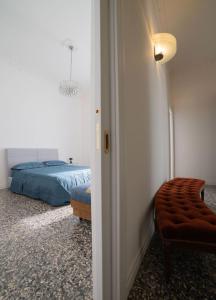 a bedroom with a bed and a chair and a lamp at AM Apartment in Cosenza