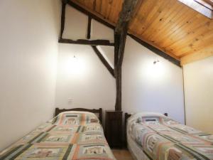 2 camas en una habitación con techo de madera en Petit tachette, en Herm