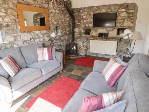 ein Wohnzimmer mit 2 Sofas und einem Kamin in der Unterkunft The Coach House in Haverfordwest