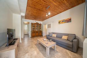 a living room with a couch and a table at Dellaporta's Cottage in Makriótika