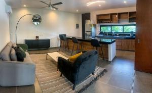 a living room with a couch and chairs and a kitchen at Moderno y Comodo Loft Asoluta in Mérida