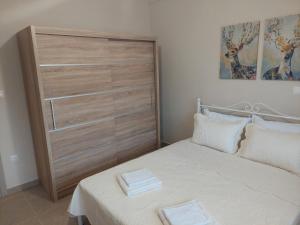um quarto com uma cama e uma grande cabeceira em madeira em Kastro Apartments em Kalivia Poligirou
