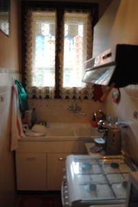 uma pequena cozinha com um lavatório e uma janela em Casa Vacanze Micetta em Bolonha