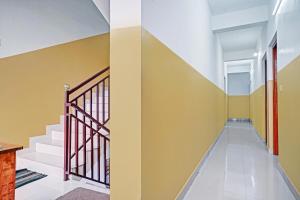 un pasillo de una casa con paredes y escaleras amarillas en OYO Flagship Thaza en Nedumbassery