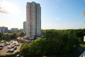 un edificio alto con auto parcheggiate in un parcheggio di Apartament, Chorzowska 216 a Katowice
