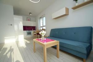 un soggiorno con divano blu e tavolo di Apartament, Chorzowska 216 a Katowice