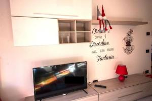 un salon avec une télévision à écran plat sur un mur dans l'établissement Riva Take It Easy, à Riva del Garda