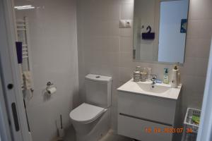 a white bathroom with a toilet and a sink at Sea view and Ifach Calpe in Calpe