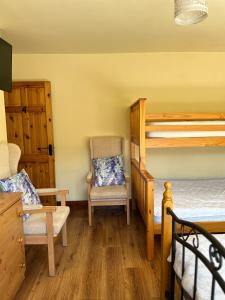 a bedroom with two bunk beds and a chair at Douglasha House V93RX64 in Killarney