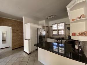 a large kitchen with a black counter top at Siena Sun Apartment 4 in Midrand