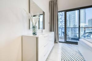 a bathroom with a white dresser and a large window at Luxury 1 Bedroom With Sea View in Dubai