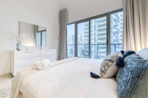 a bedroom with a white bed with a large window at Luxury 1 Bedroom With Sea View in Dubai