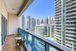 a balcony with chairs and a view of a city at Luxury 1 Bedroom With Sea View in Dubai