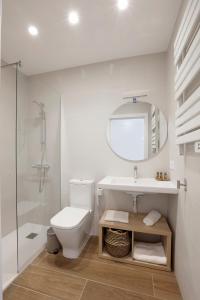 a bathroom with a toilet and a sink and a mirror at Mendi Azpi Rooms in Mutriku