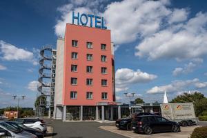 um grande hotel cor-de-rosa com uma placa em cima em Qualitel Wilnsdorf em Wilnsdorf