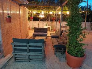 un patio con un gruppo di sedie e un pergolato di Casa vacanze Salento: Villa Charlotte a Torre Santa Susanna