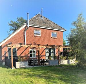Cette grande maison en briques rouges possède une terrasse couverte. dans l'établissement Heerlijk Gaanderhei, à Gaanderen