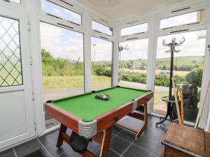 a pool table in a room with windows at Aberceiro Bungalow in Bow Street