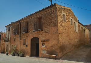 an old brick building with a bench in front of it at Lo Molí de Bot in Bot