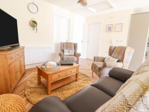 a living room with a couch and a tv at Varley Villa in Newtown