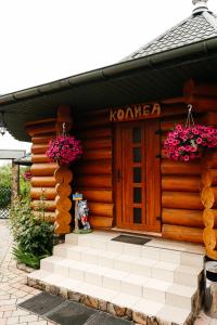 a wooden cabin with pink flowers on the door at Chudodievo in Chynadievo Mini-Hotel in Chynadiyovo