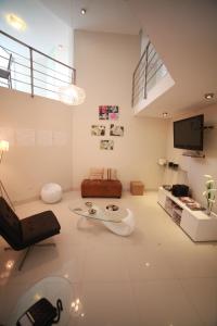 a white living room with a couch and a tv at Suche Park Hotel in Piura