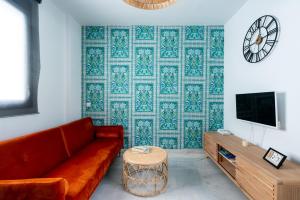 un soggiorno con divano rosso e TV di Alf8 Apartamento en Triana con dos terrazas a Siviglia