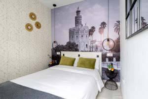 una camera con un letto bianco e una foto di una torre di Alf8 Apartamento en Triana con dos terrazas a Siviglia